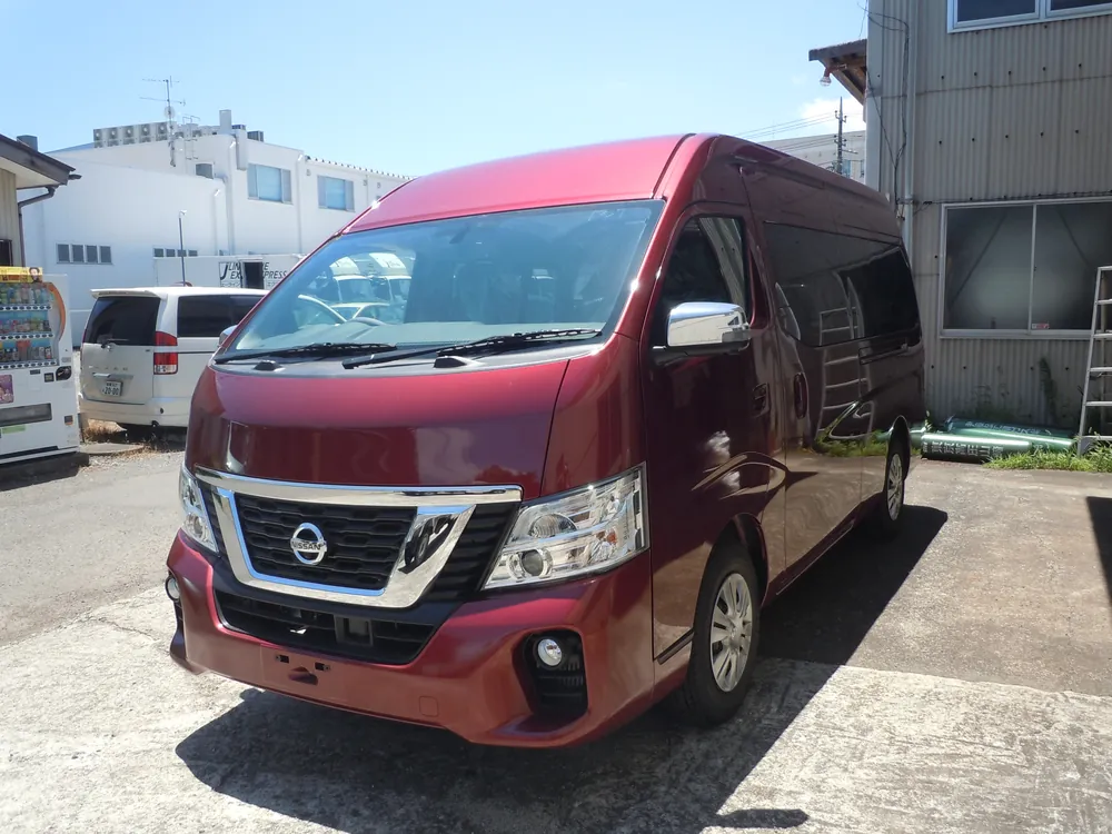 工房の前に停めた赤いハイルーフの日産NV350キャラバン