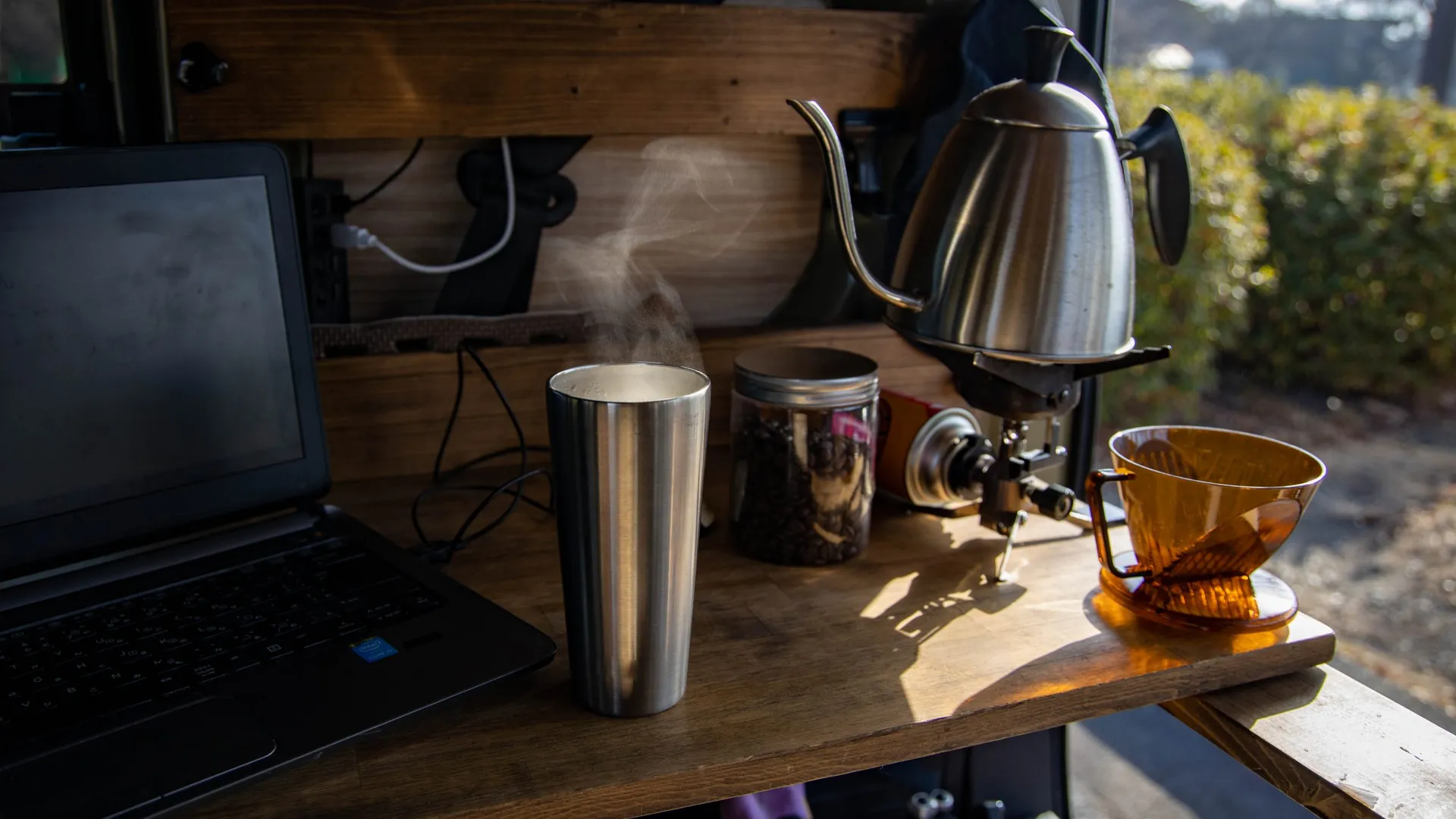 車内に組んだ木のテーブルでコーヒーを淹れる様子