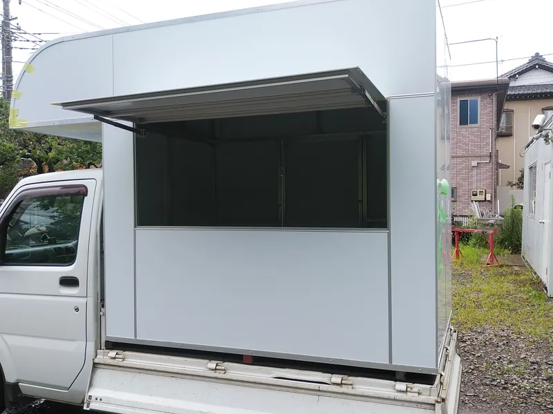 跳ね上げ式の販売窓口を備えた軽トラックのキッチンカー