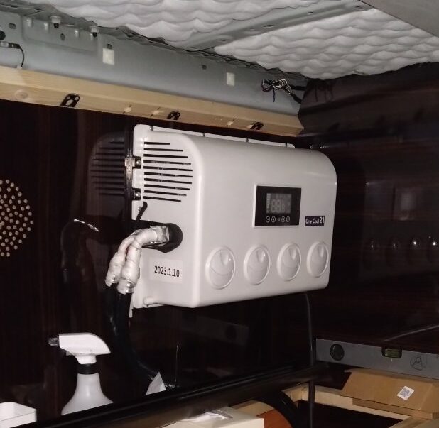 車内上部に取り付けたONE COOL 12Vエアコンの室内機。丸形吹き出し口4連とデジタル表示、断熱材を巻いた配管